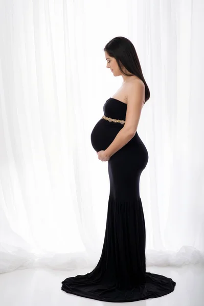 Femme enceinte souriante dans une robe noire — Photo