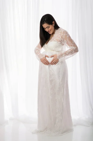 Lachende zwangere vrouw in een witte Lace Gown — Stockfoto