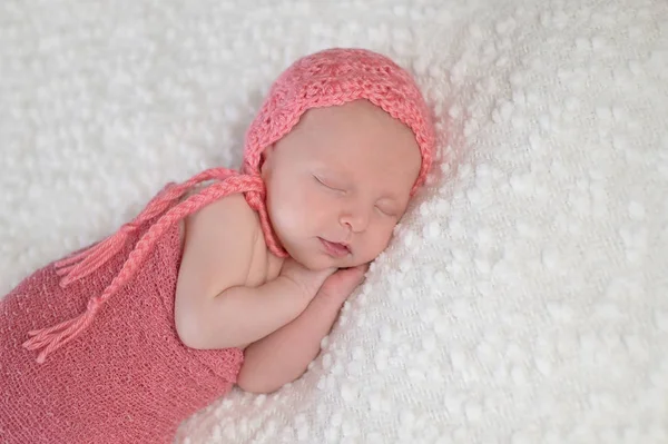 Bebê recém-nascido usando uma capota de pêssego — Fotografia de Stock