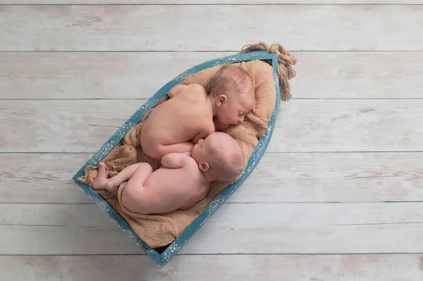 日間の古い兄弟 ツイン 新生児 赤ちゃん男の子の小さな 木製ボートで眠っています 木材の背景のスタジオで撮影します — ストック写真