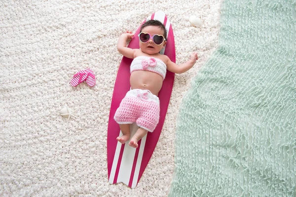 Novorozenec holčička na surfové prkno — Stock fotografie