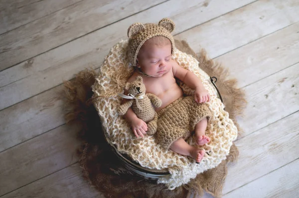 Bebé con sombrero de oso y juguete de oso de peluche — Foto de Stock