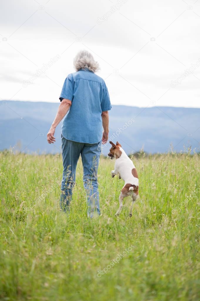 Senior Woman Walking in a Field with her Dog