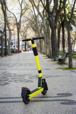 Sokakta kiralık sarı elektrikli scooter.