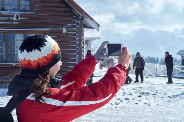 Młoda kobieta fotografowane góry zimą — Zdjęcie stockowe