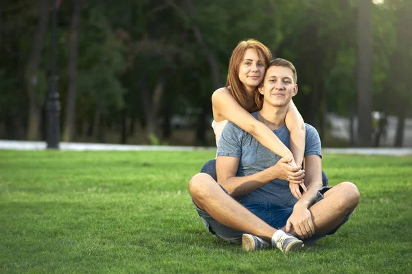 爱的情侣坐在公园的草地上 — 图库照片