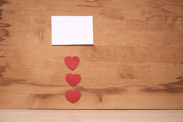 many small hearts and a blank sheet of paper to record