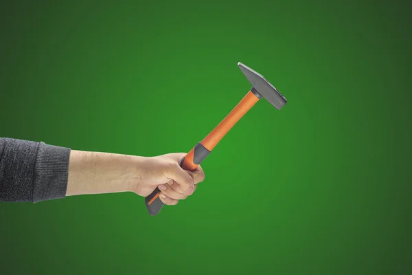 Mano del hombre sosteniendo un martillo sobre un fondo liso — Foto de Stock