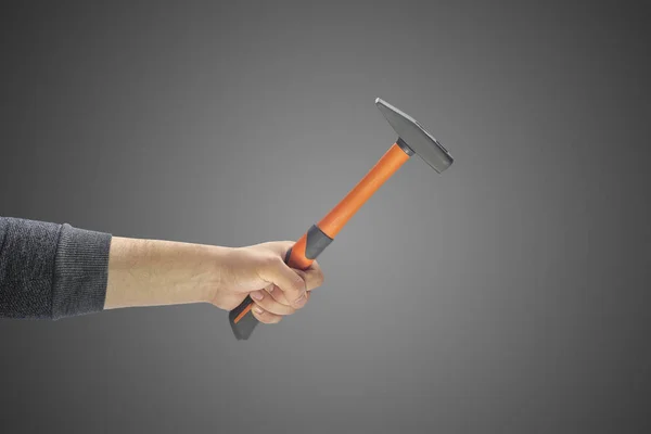 Iemands hand met een hamer op een effen achtergrond — Stockfoto