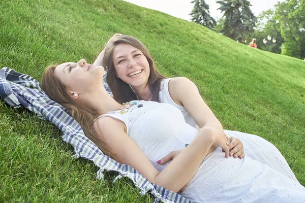 Two friends lying on the grass in the park — Stock Photo, Image