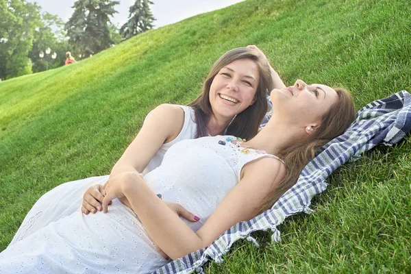 Two friends lying on the grass in the park — Stock Photo, Image