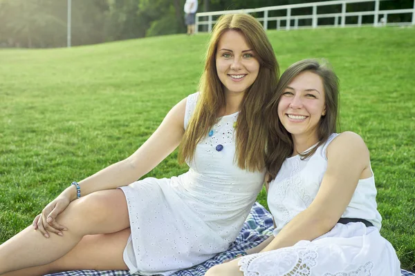 Twee vrienden liggend op het gras in het park — Stockfoto