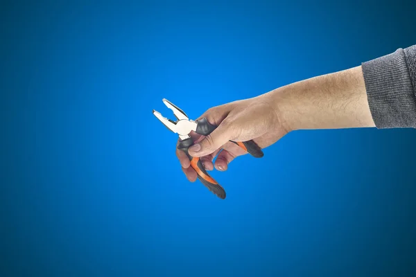 Mão de homem segurando um alicate — Fotografia de Stock