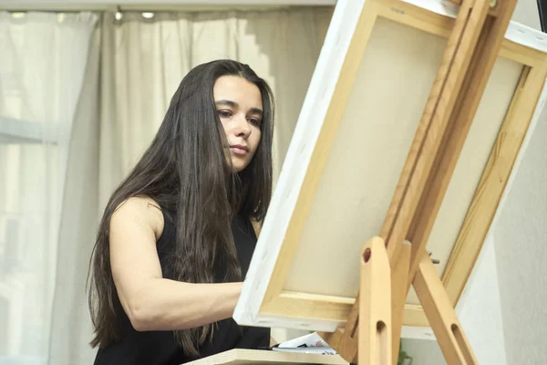 Mujer creativa pinta un retrato sobre lienzo —  Fotos de Stock