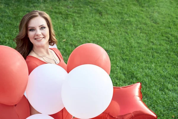 Mooie bruid met ballonnen in het park — Stockfoto