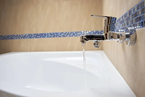 Wasser fließt aus dem Wasserhahn im Bad — Stockfoto