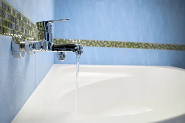 Wasser fließt aus dem Wasserhahn im Bad — Stockfoto
