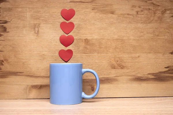 Cup of coffee with hearts on a wooden background — Stock Photo, Image