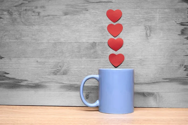 Cup of coffee with hearts on a wooden background — Stock Photo, Image