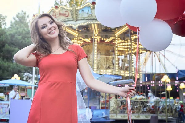 Mooie bruid met ballonnen in het park — Stockfoto