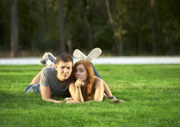 Pareja enamorada yace en el césped en el parque —  Fotos de Stock