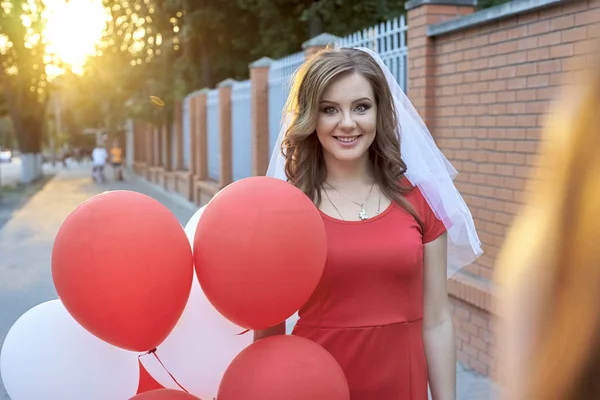 Mooie bruid met ballonnen in het park — Stockfoto