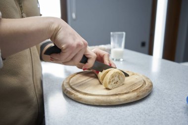 Kadın mutfakta ekmek keser