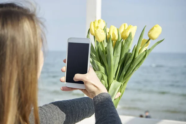 Young woman with flowers making selfie — Stock Photo, Image