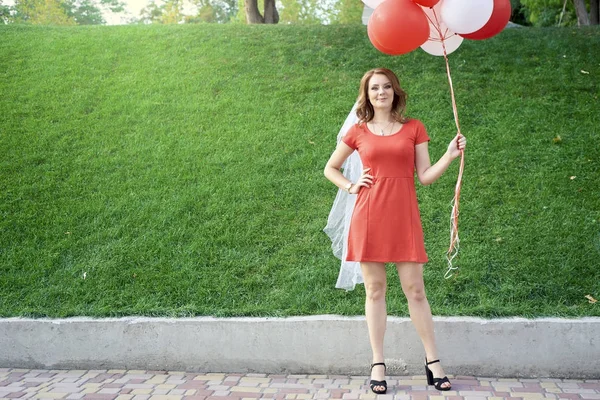 Piękna panna młoda z balonami w parku — Zdjęcie stockowe
