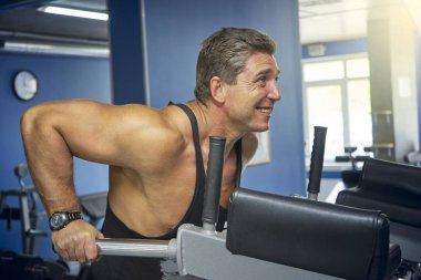 Yetişkin vücut geliştirmeci çubuklardan sıkılmış