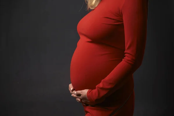 Mooie zwangere vrouw houdt buik met handen — Stockfoto