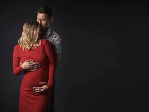 Man kramar en gravid kvinna och kysser henne — Stockfoto