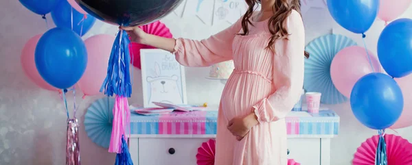 Mulher grávida perto de rosa e azul decorações no sexo revelar festa — Fotografia de Stock