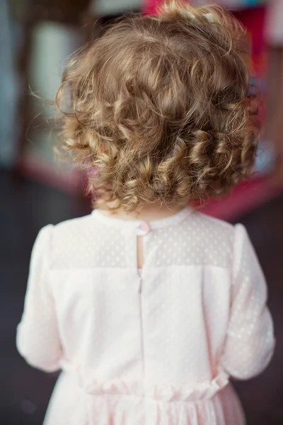 Kleines lockiges Mädchen im rosa Kleid — Stockfoto