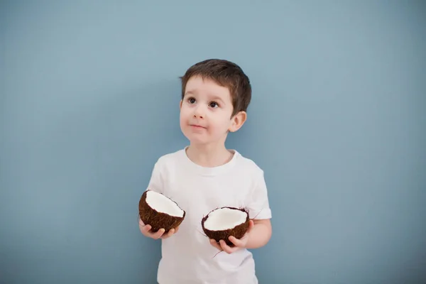 Mały Chłopiec Białej Koszulce Żółtych Spodenkach Dwoma Kokosami Tle Niebieskiej — Zdjęcie stockowe