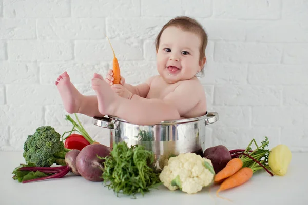 新鮮な野菜の近くの調理鍋に座っている小さな白人の少年 健康的な食事 — ストック写真