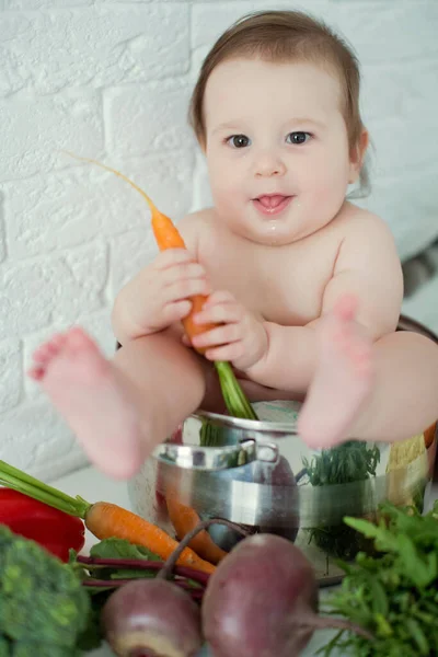 新鮮な野菜の近くの調理鍋に座っている小さな白人の少年 健康的な食事 — ストック写真