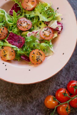 Lezzetli ve taze domates ve siyah susam tohumlu diyet salatası.