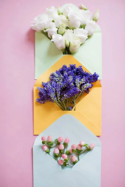 Blå Gula Och Gröna Kuvert Med Blommor Inuti Rosa Bakgrund — Stockfoto