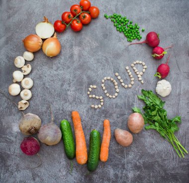 Gri arka planda taze sebzeli kompozisyon, metin için boşluk. Çiğ bezelyeden yapılmış 