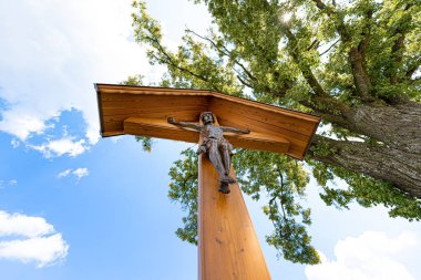 Koridor, mavi gökyüzü ve dalların önünde İsa ile kesişiyor.