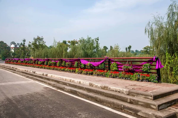 Цветы и деревья Biannan во всемирном саду на перилах небольшого моста — стоковое фото