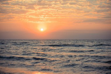 Turuncu gölgelerle denizin üzerinde güzel bir gün doğumu