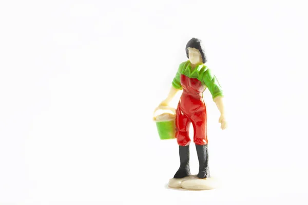 黒いブーツと緑のシャツと労働者の男の人形白い背景と緑のバケツを運ぶ赤いオーバーロール — ストック写真