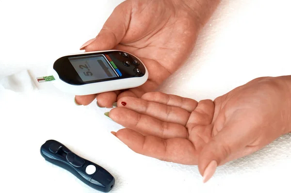 Ein Diabetiker kontrolliert seinen Blutzucker. die Frau wird zu Hause mit Lanzette und Glukometer selbst getestet. — Stockfoto