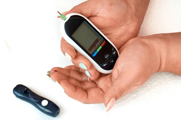 糖尿病患者が血糖値をチェックしてる彼女は家でランセットとグルメで自己テストされています. — ストック写真