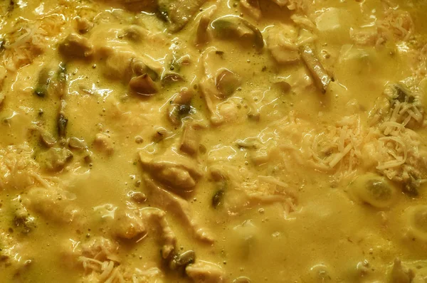 Close up fried mushrooms and chicken fillet in cheese sauce.