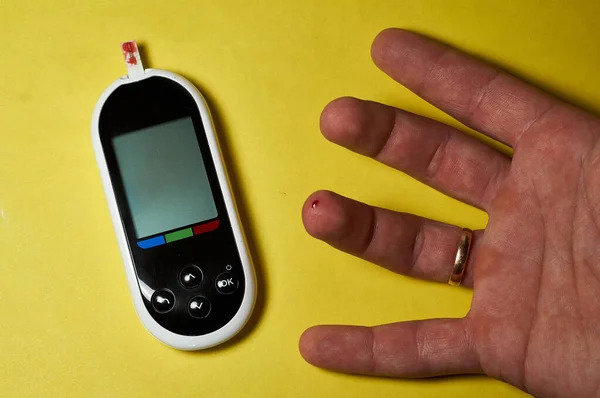 糖尿病患者が血糖値をチェックしてる 家で男の手を閉じる ランセットとGlucometerとセルフテスト — ストック写真