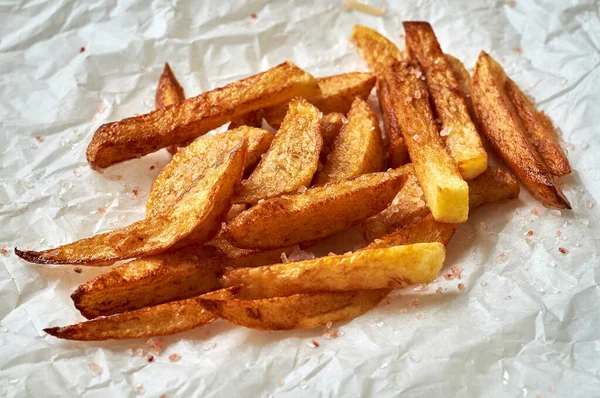 Tasty homemade potato french fries on white paper background — Stock Photo, Image