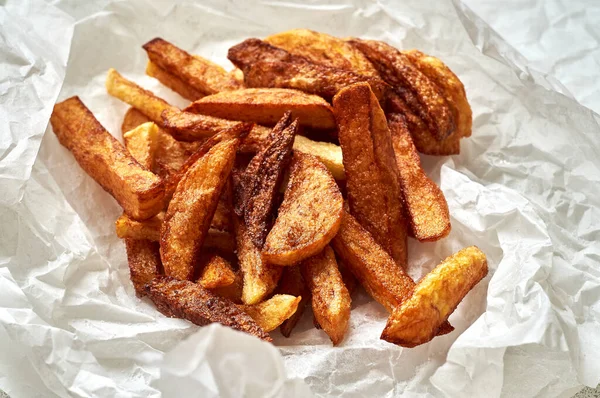 Beyaz kâğıt üzerinde ev yapımı patates kızartması.